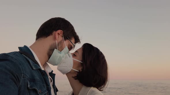 Couple kisses with mask on the beach