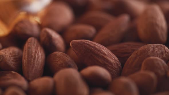 Thick honey dripping over almonds. Slow Motion.