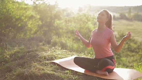 Woman practicing yoga at sunset.