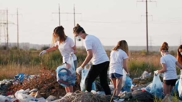 Group of Eco Volunteers Cleaning Up Area of Dump Near the Field During Sunset Slow Motion Close Up