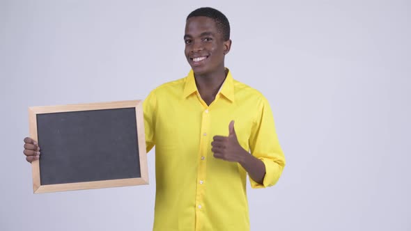 Young Happy African Businessman Holding Blackboard and Giving Thumbs Up