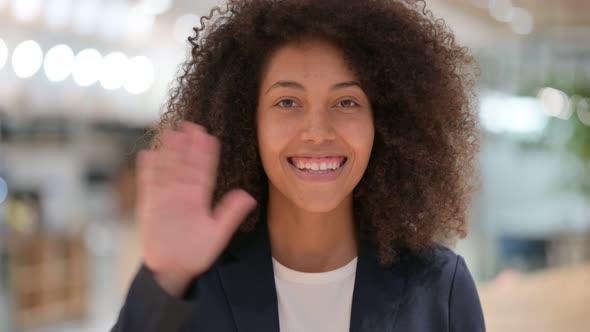 Cheerful Young African Businesswoman Waving at the Camera 