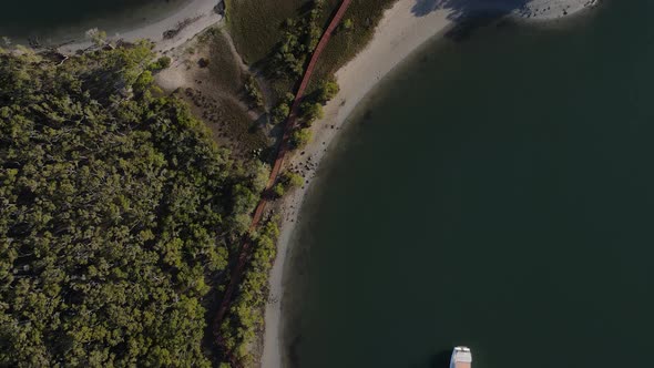 Fasting drone video looking down on a secret timber boardwalk winding through a coastal conservation