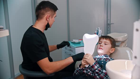 A Little Boy Having a Treatment in the Dentistry - the Boy Looking in the Mirror