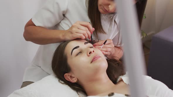 Caucasian woman lying down having her eyebrows dyed