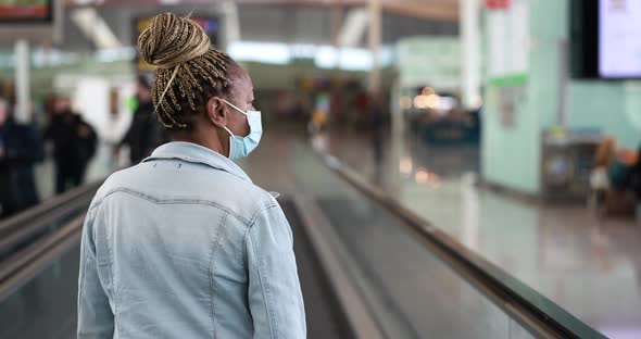 Mature african woman wearing safety face mask inside the  international airport