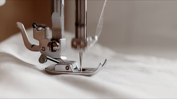 The Needle of a Sewing Machine Makes a Thread Stitch, Sewing White Fabric on a Sewing Machine 
