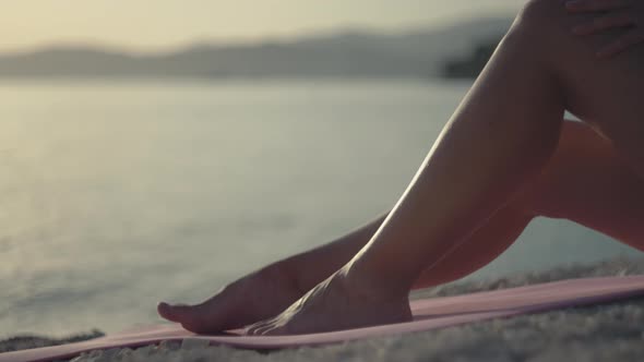 Women's Feet By the Sea and Women's Hands Smear Sunscreen