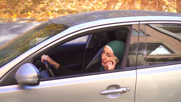 Muslim Businesswoman in Hijab in the Car and Talking on the Phone