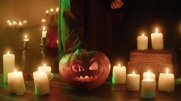 Putting Burning Candle Into Carved Pumpkin Closeup