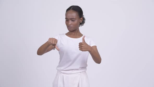Young Beautiful African Woman Choosing Between Thumbs Up and Thumbs Down