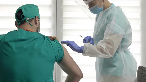 Nurse Giving a Doctor a Coronavirus Vaccine