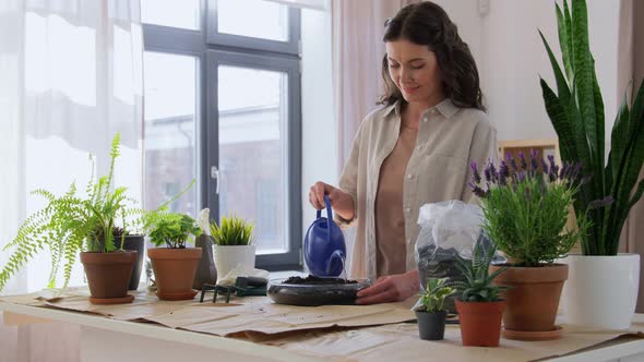 Woman Watering Soil in Vase for Flowers at Home