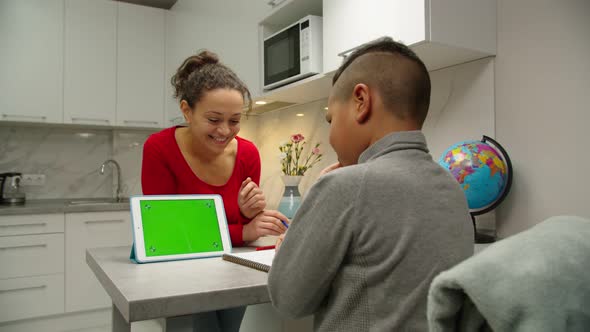 Mom Using Tablet with Chroma Key Green Screen for Homeschooling