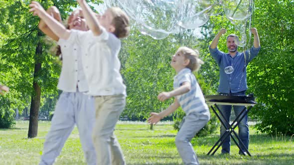 Professional Performer Blowing Large Bubbles for Kids in Park