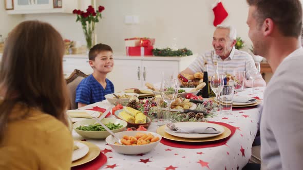 Caucasian family sitting on dining table enjoying lunch together during christmas at home