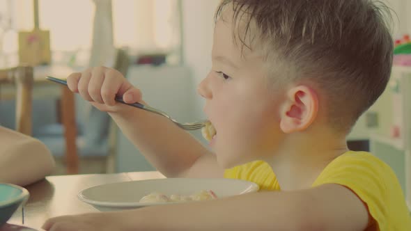 Happy Child Eating Healthy Organic and Vegan Food in Restaurant