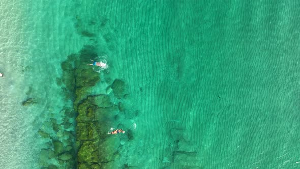 A woman swims in the sea aerial view 4K