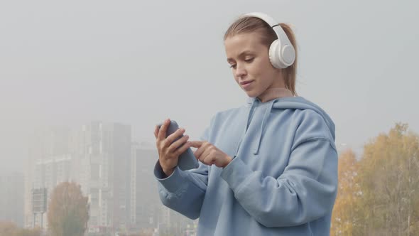 Female Jogger Listening Music in Headphones on Foggy Morning