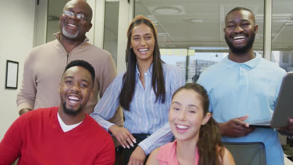 Portrait of diverse male and female business colleagues smiling in office