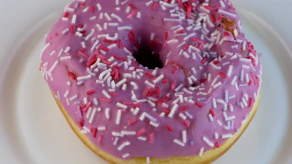 Delicious appetizing dessert sweet donut on a plate close-up rotates.