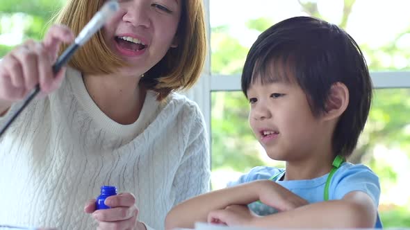 Cute Asian Child And Mother Painting Together