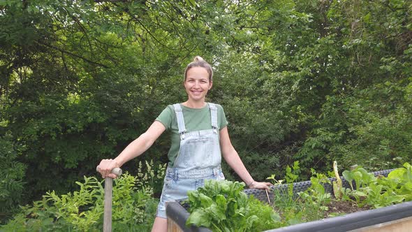 Slow motion shot of smiling gardener at raised bed