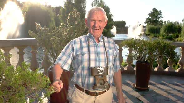 Man Smiling and Holding Camera.
