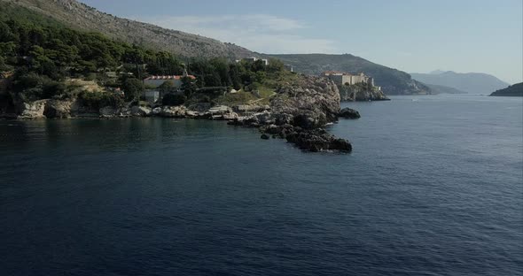 Aerial shot of Dubrovnik. the camera passes low to the sea and over a rocky coast, then rises to sho