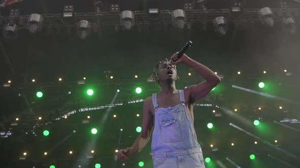 Black rapper in overalls on stage