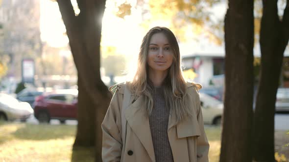 Blonde Smiling Woman Outdoors in Lens Flares in Autumn