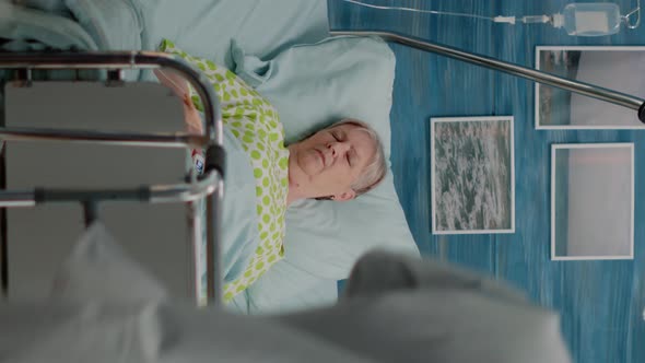 Vertical Video Doctor and Nurse Helping Elder Patient with Disease in Bed