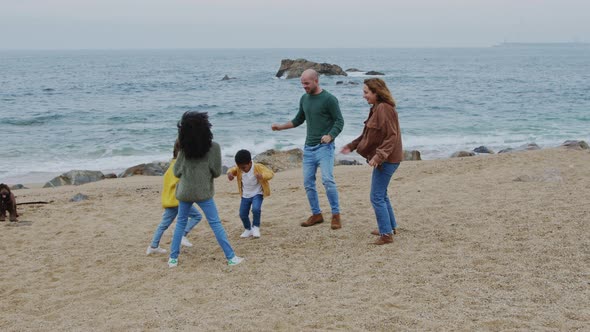 Young Family Outdoor Leisure On Ocean Coast