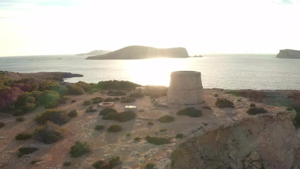 Sunset aerial view of pirate lookout tower in Ibiza.