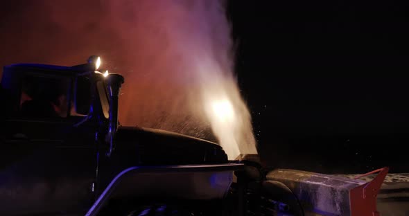 The Grader Removes Snow On The Road Outside The City At Night