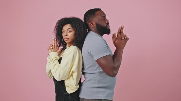 African American Man and Woman Posing Back to Back Holding Hands Like Guns and Shooting to Camera