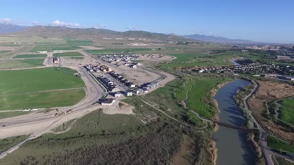 Aerial view of new housing construction in a valley next to a winding river