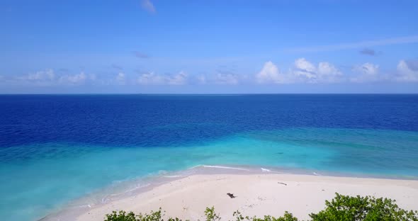 Tropical fly over abstract shot of a white paradise beach and blue water background in vibrant 4K