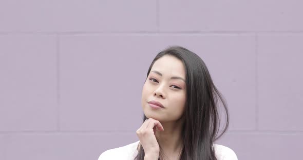 Portrait of flirting Chinese woman, purple background