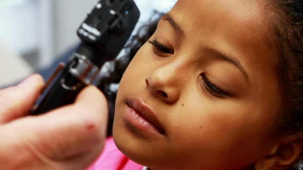 Doctor examining patients eye with otoscope