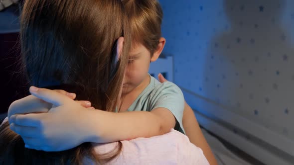 Portrait of Little Upset and Sad Toddler Boy Hugging and Kissing His Mother Before Going To Sleep at