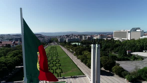 Close Up Aerial View of Portugal Flag Waving in the Wind on Eduardo VII Park Lisbon