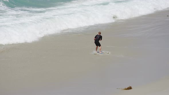 Man surfing on a sandy beach alt
