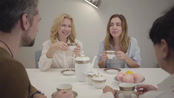 Portrait of Relatives or Friends of Different Ages Sitting at the Table, Drinking Tea, Coffee