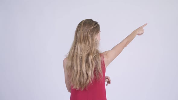 Rear View of Young Blonde Woman Directing and Pointing Finger