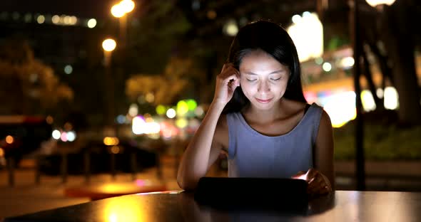 Asian Woman use of tablet computer at night 