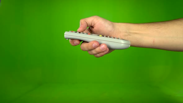 Hand Changing Channels with Television Remote. Side View. Green Screen