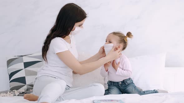 Mother Is Putting a Mask on Daughter's Face