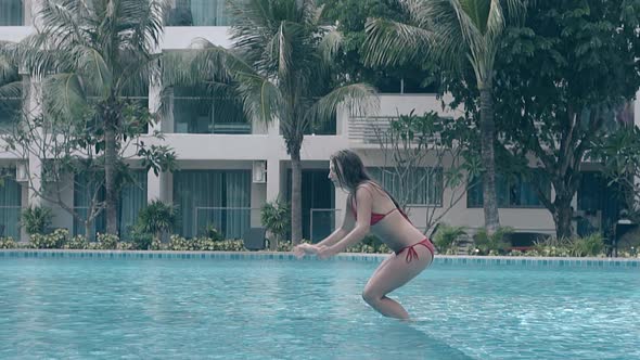 Girl in Bikini Jumps Into Pool Water at Resort Slow Motion