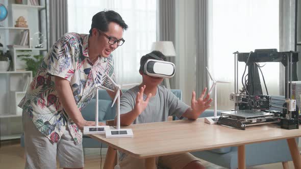 Asian Father Teach His Son While Wearing Vr Glasses With Electric Wind Turbine Model